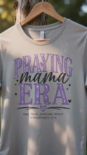 Load and play video in Gallery viewer, Praying Mama Era T-Shirt | Christian Mom Faith Tee | Faith-Based Graphic Shirt
